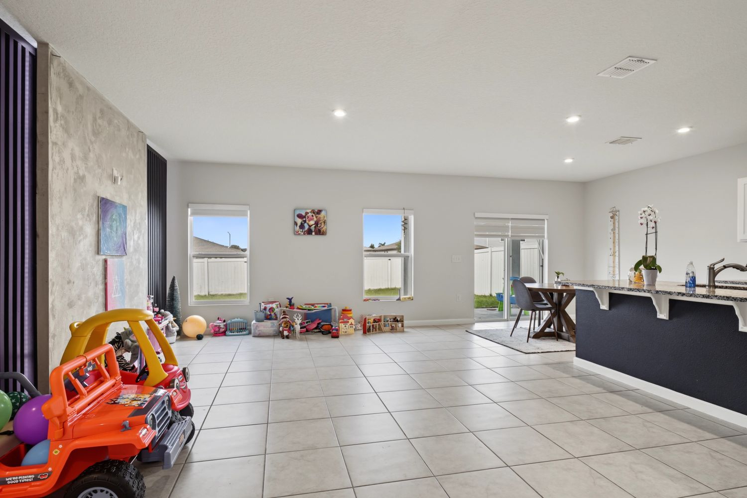 Original: the same living room filled with children's toys and ride-on cars