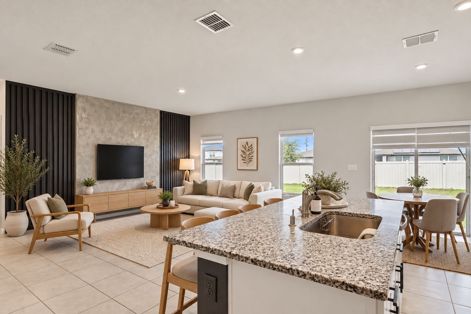 Virtually staged: living area seen from the kitchen island, with a sofa, lounge chair, bar stools and dining table