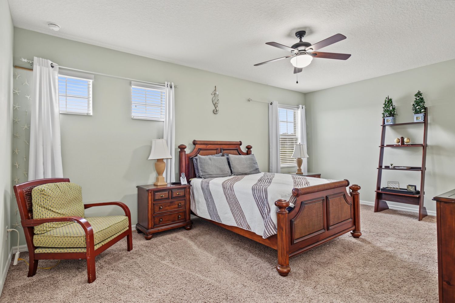Original: the same bedroom with dated striped bedding and a patterned chair cushion