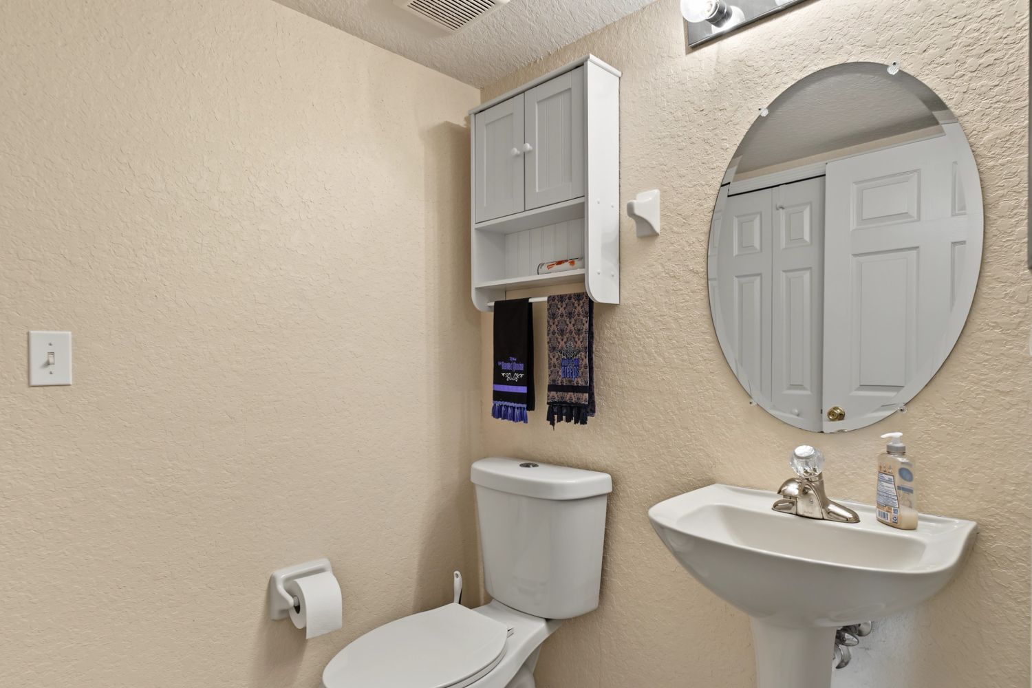 Original: the same powder room with personal themed hand towels and bare walls