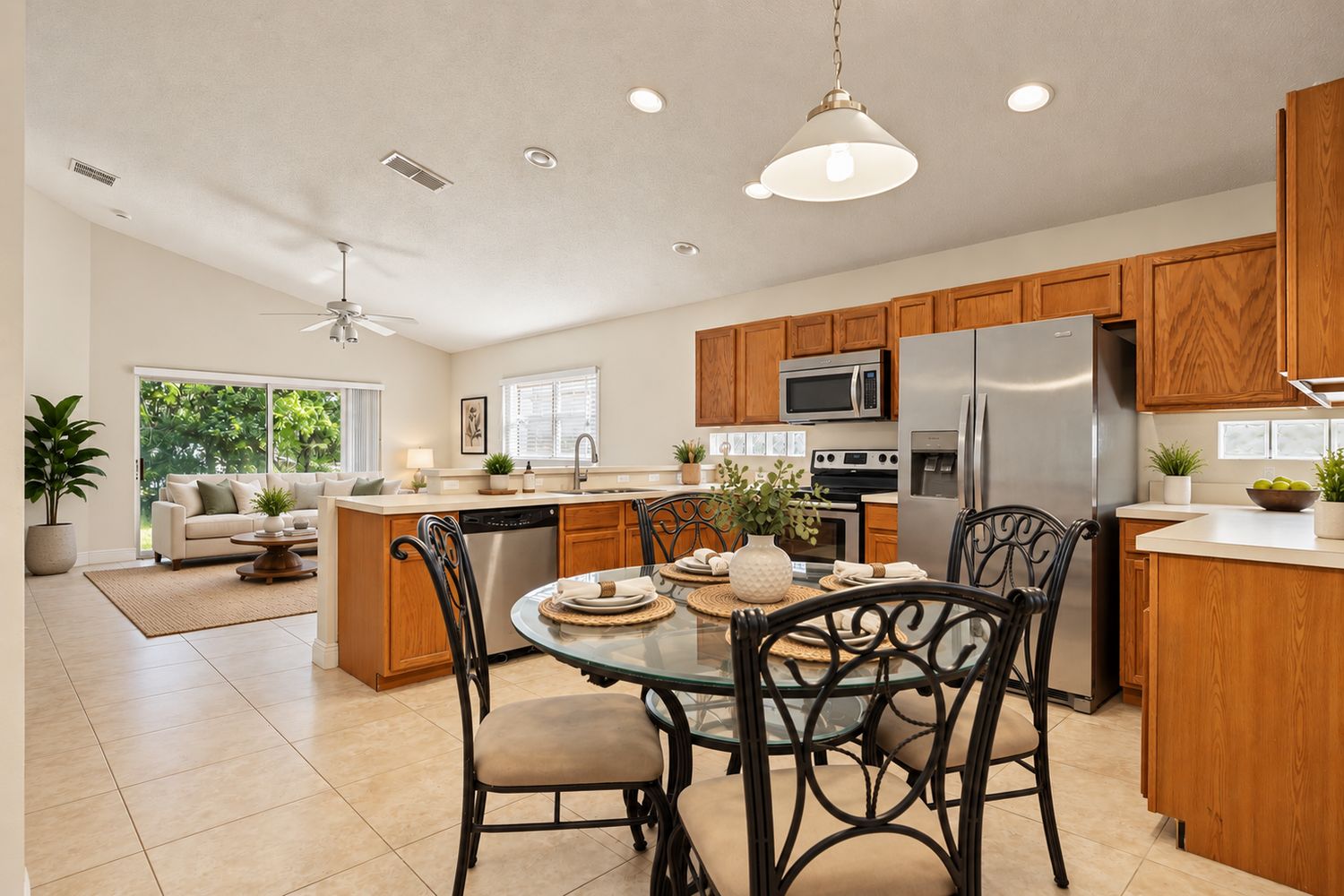 Virtually staged: kitchen with cleared counters, a set dining table and a furnished living area beyond