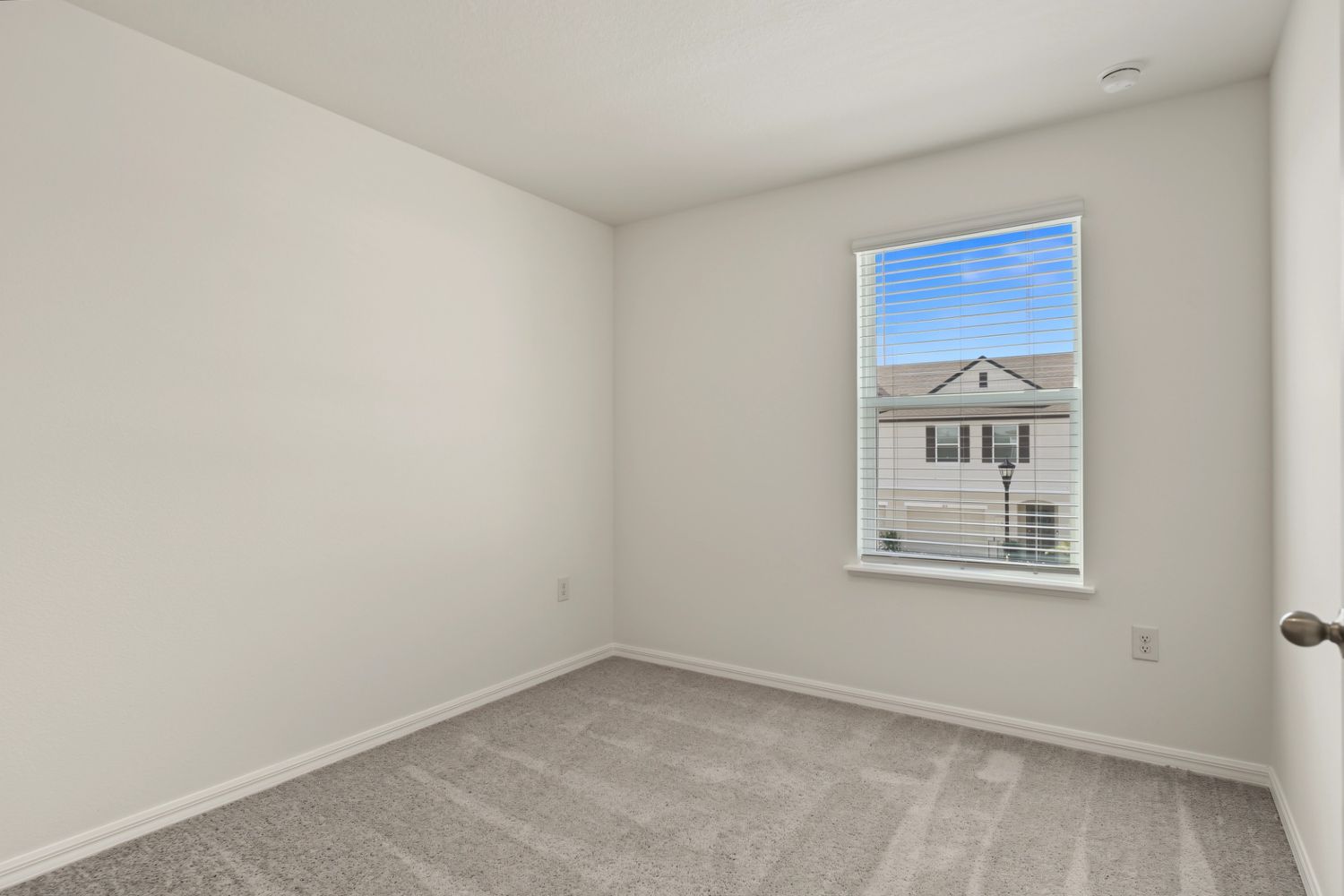 Original: the same small bedroom, completely empty with gray carpet
